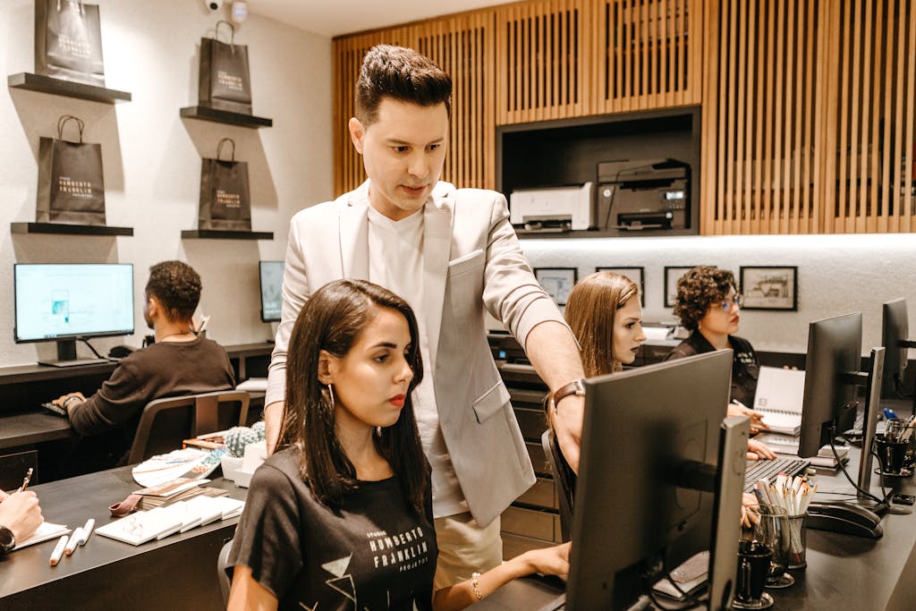 About Us Man Teaching Woman in Front of Monitor